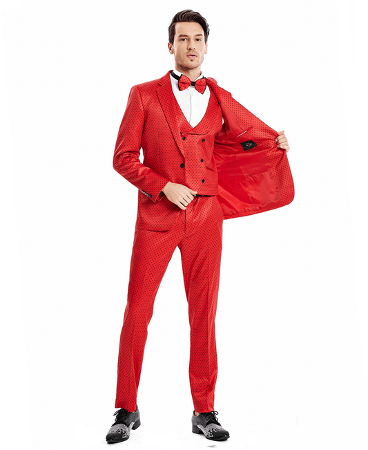 A man wearing a red suit with black polka-dots and a matching bowtie. 3-piece suit with a double-breasted vest.